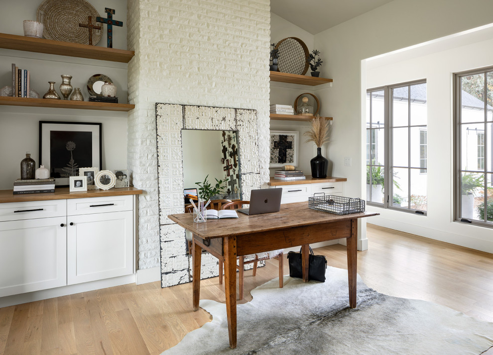 Inspiration pour un grand bureau rustique de type studio avec un mur gris, parquet clair, aucune cheminée, un bureau indépendant, un sol marron et un plafond voûté.