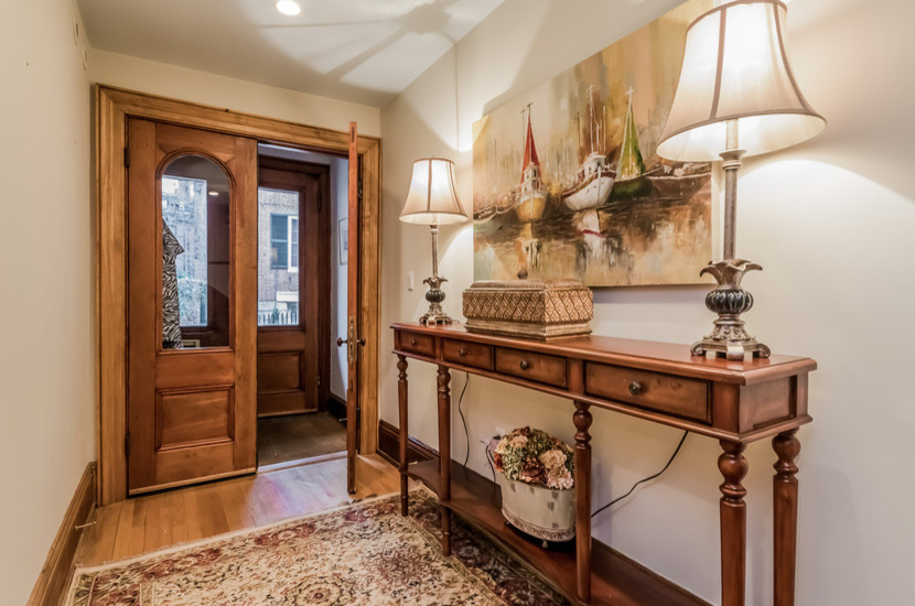Mid-sized traditional vestibule in Boston with white walls, dark hardwood floors, a double front door, a dark wood front door and brown floor.