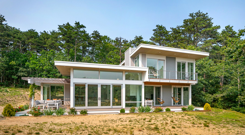 На фото: двухэтажный, серый частный загородный дом среднего размера в стиле модернизм с облицовкой из ЦСП, плоской крышей и отделкой дранкой с
