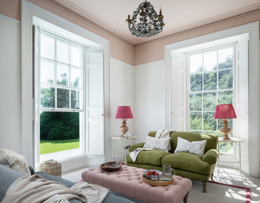 На фото: гостиная комната в классическом стиле с розовыми стенами и ковровым покрытием с