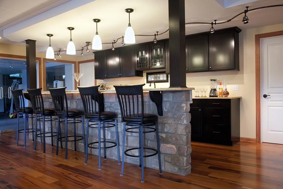 Mid-sized traditional galley seated home bar in Philadelphia with shaker cabinets, black cabinets and medium hardwood floors.