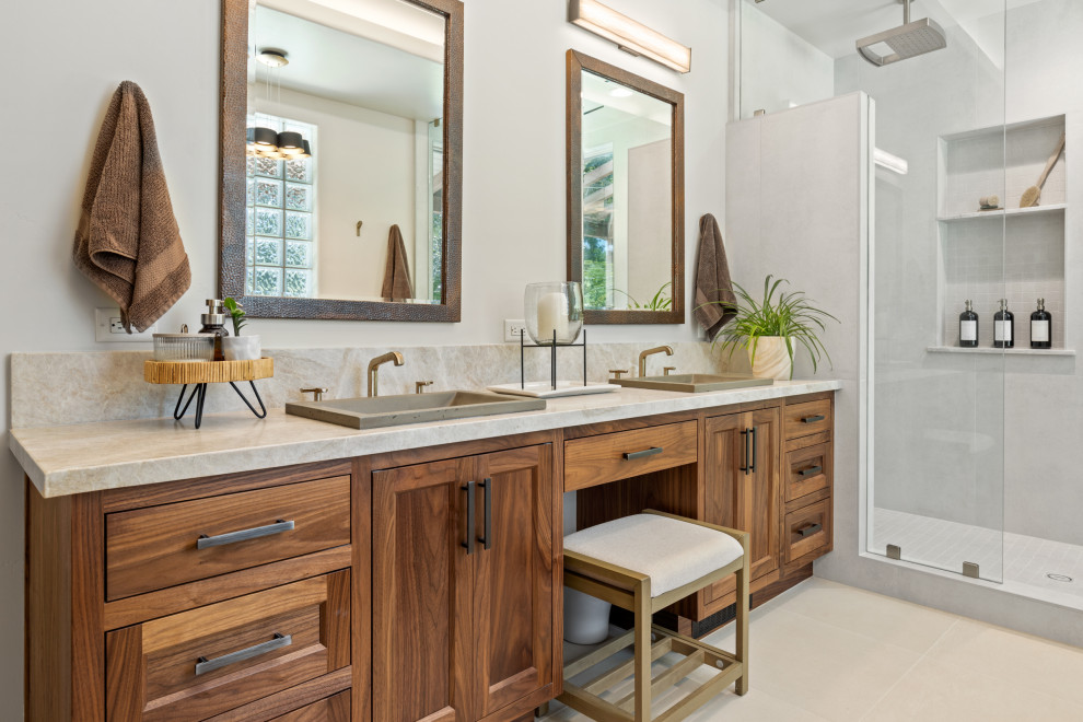 Photo of a large modern master bathroom in Other with shaker cabinets, medium wood cabinets, a freestanding tub, an alcove shower, a two-piece toilet, white tile, porcelain tile, white walls, porcelain floors, a drop-in sink, quartzite benchtops, white floor, a hinged shower door, white benchtops, an enclosed toilet, a double vanity and a built-in vanity.