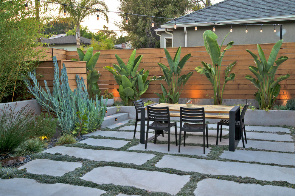 Idée de décoration pour une terrasse arrière minimaliste de taille moyenne avec un foyer extérieur et une dalle de béton.