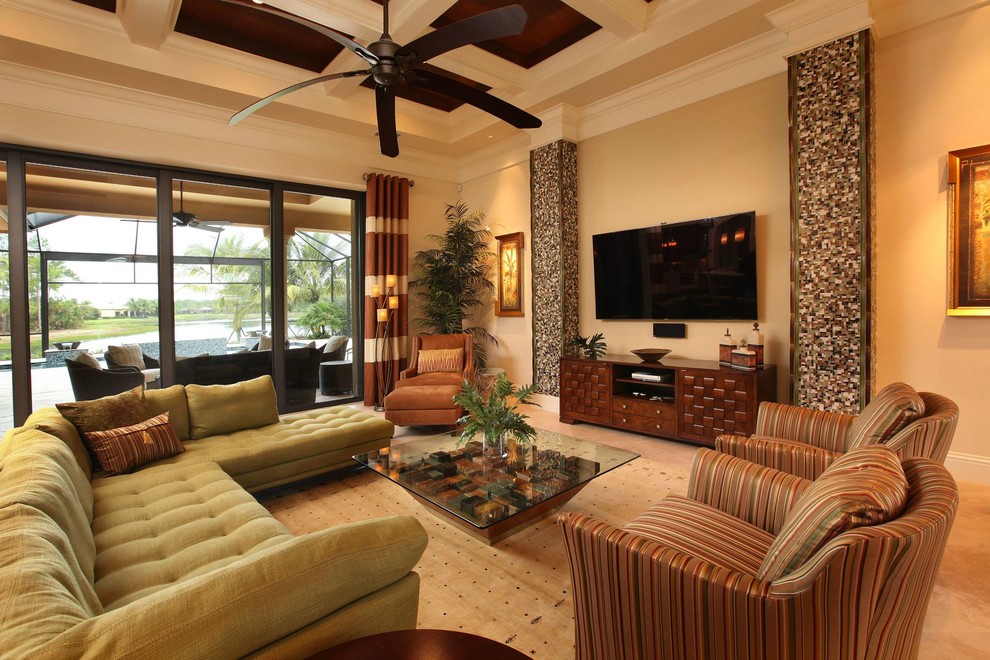 Inspiration for a large tropical open concept living room in Miami with beige walls, ceramic floors, no fireplace, a wall-mounted tv and beige floor.