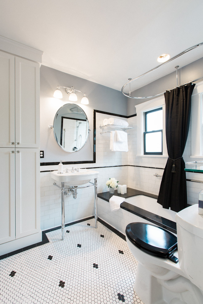 This is an example of a mid-sized arts and crafts bathroom in San Francisco with furniture-like cabinets, white cabinets, an undermount tub, a shower/bathtub combo, a two-piece toilet, white tile, ceramic tile, grey walls, ceramic floors, a console sink and granite benchtops.