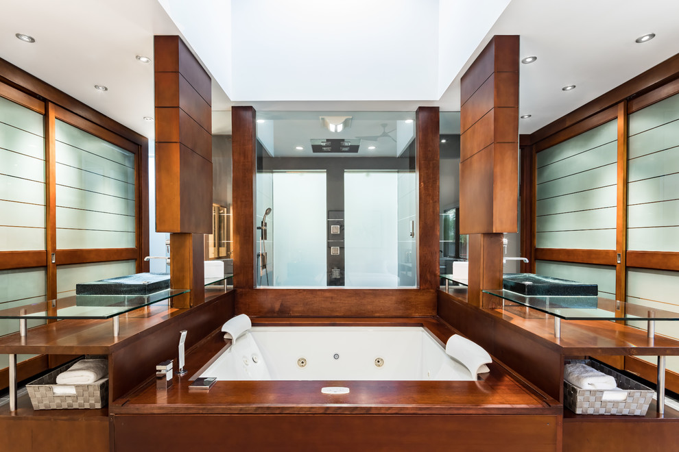 Photo of a large modern master bathroom in San Francisco with open cabinets, brown cabinets, a hot tub, a double shower, a wall-mount toilet, brown tile, dark hardwood floors, glass benchtops, brown floor and an open shower.