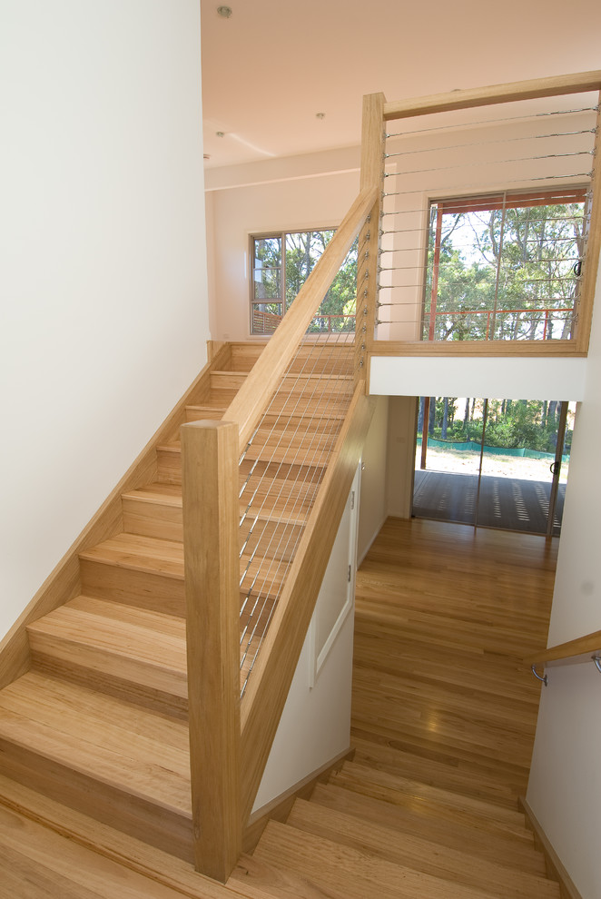 This is an example of a mid-sized beach style wood straight staircase in Sydney with wood risers.