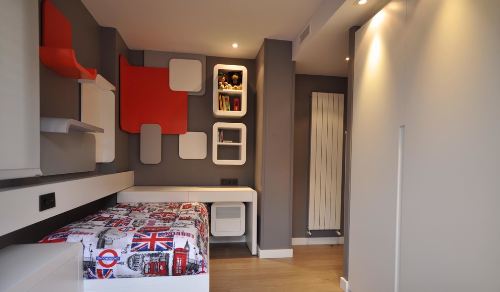 This is an example of a mid-sized contemporary gender-neutral kids' bedroom for kids 4-10 years old in Madrid with multi-coloured walls and medium hardwood floors.