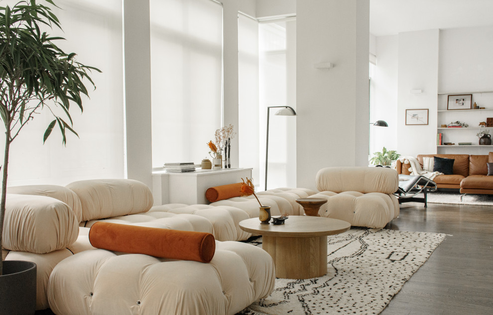 Cette image montre un salon design avec un mur blanc, parquet foncé et un sol marron.
