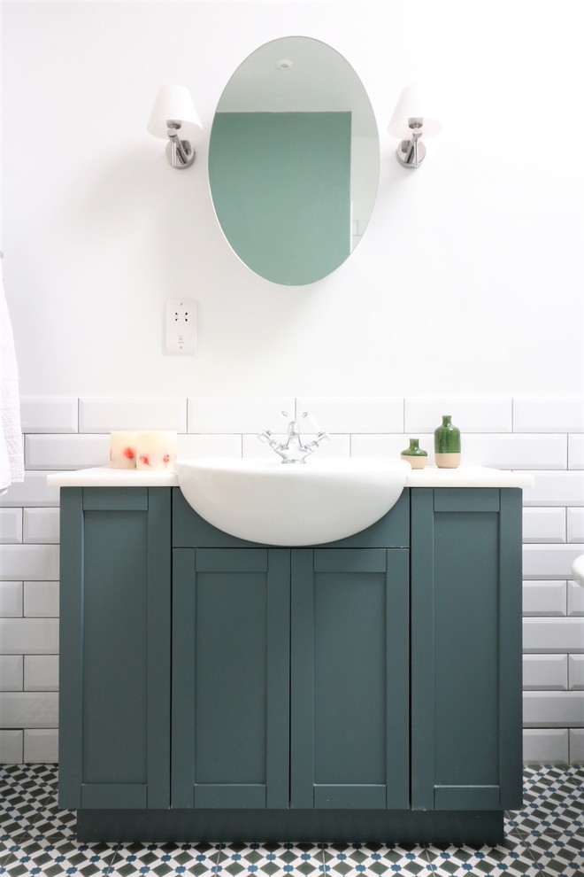 Inspiration for a mid-sized traditional kids bathroom in Cambridgeshire with shaker cabinets, blue cabinets, a claw-foot tub, an open shower, white tile, ceramic tile, white walls, cement tiles, a drop-in sink, quartzite benchtops, multi-coloured floor and white benchtops.