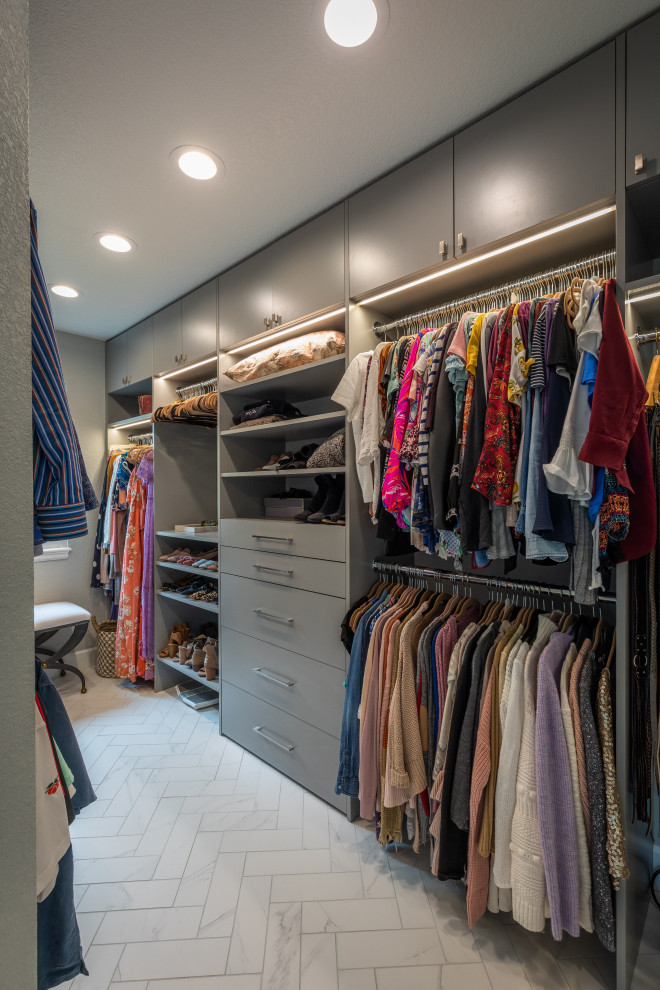 Diseño de armario vestidor unisex tradicional renovado grande con armarios con paneles lisos, puertas de armario grises, suelo de baldosas de porcelana y suelo blanco