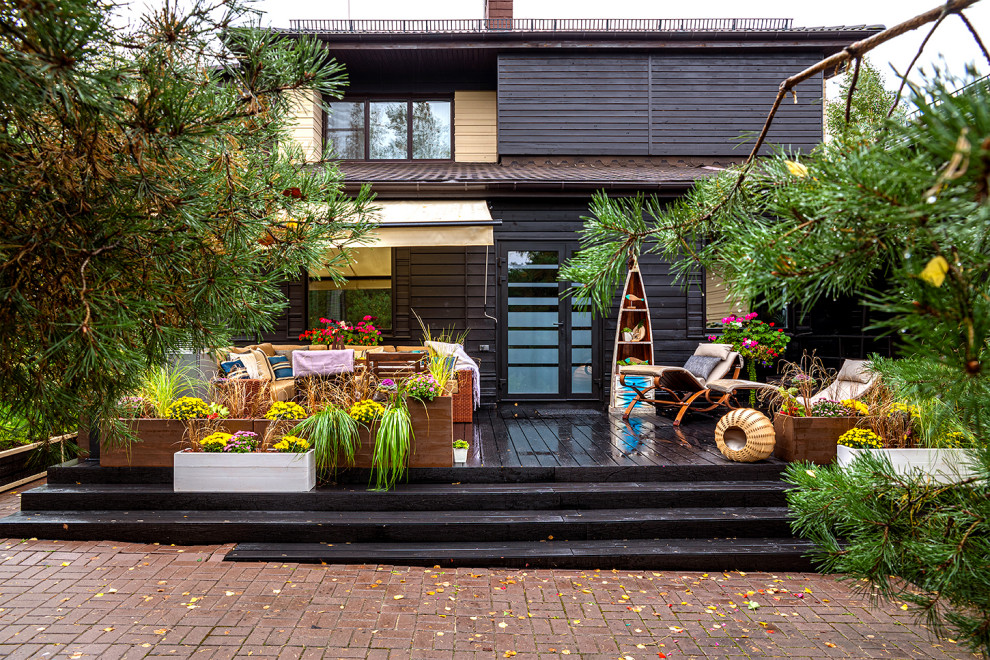 Mediterranean backyard verandah in Moscow with a roof extension and a container garden.