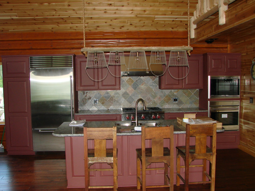 Mid-sized mountain style single-wall medium tone wood floor and beige floor open concept kitchen photo with a double-bowl sink, raised-panel cabinets, red cabinets, granite countertops, gray backsplash, stone tile backsplash, stainless steel appliances and an island
