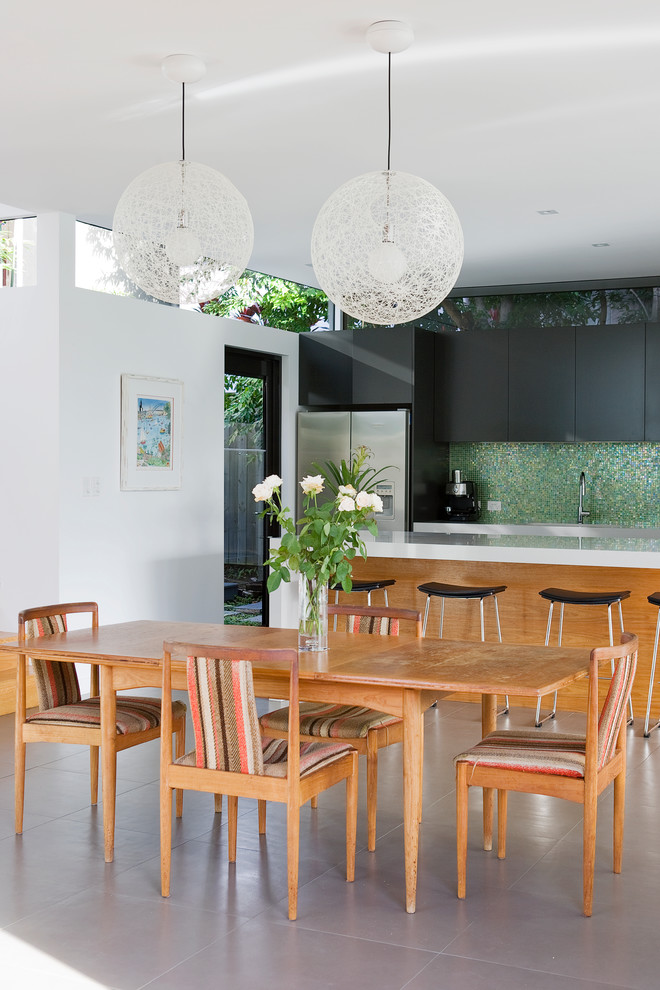 This is an example of a contemporary kitchen/dining combo in Sydney with white walls and no fireplace.