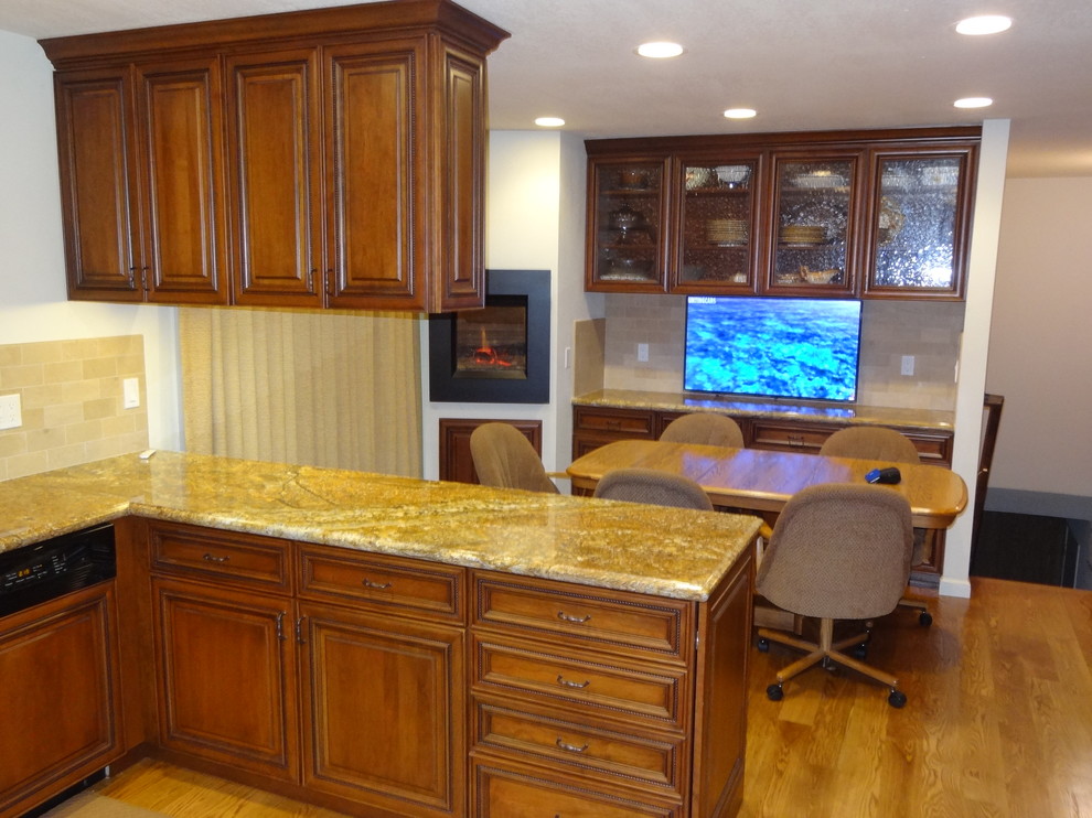 Traditional u-shaped eat-in kitchen in San Francisco with an undermount sink, raised-panel cabinets, medium wood cabinets, granite benchtops, beige splashback, subway tile splashback and panelled appliances.