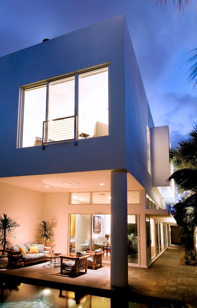 This is an example of a small modern backyard patio in Miami with a roof extension.