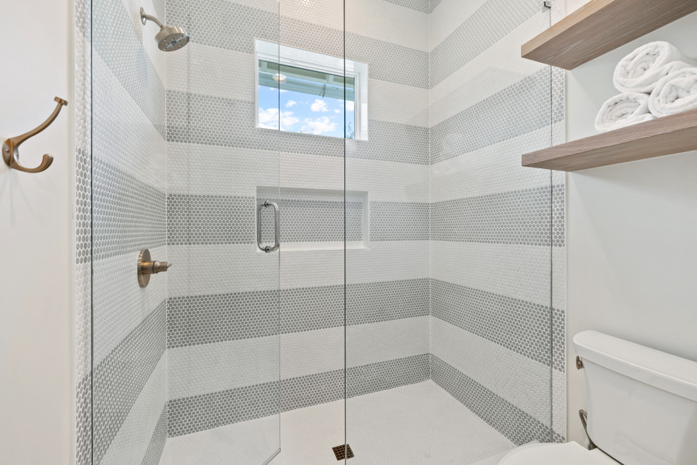 This is an example of a mid-sized beach style kids bathroom in Miami with shaker cabinets, light wood cabinets, blue tile, porcelain tile, white walls, ceramic floors, an undermount sink, engineered quartz benchtops, white floor, a hinged shower door, white benchtops, a double vanity and a built-in vanity.