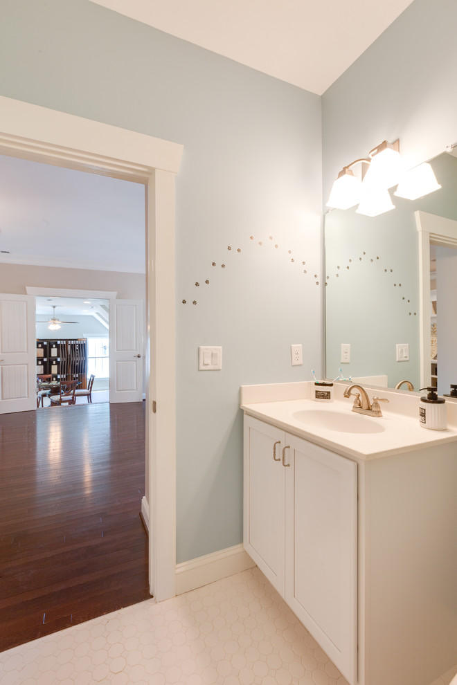Photo of a large traditional kids bathroom in Other with an integrated sink, shaker cabinets, white cabinets, solid surface benchtops, an alcove tub, a corner shower, a two-piece toilet, white tile, porcelain tile, blue walls and porcelain floors.
