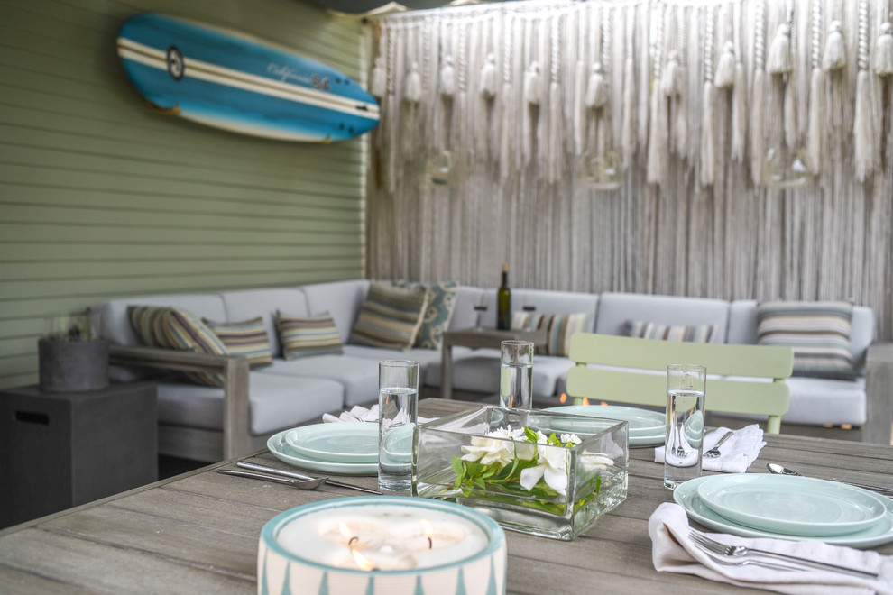 Inspiration for a small beach style backyard patio in Santa Barbara with a fire feature and an awning.