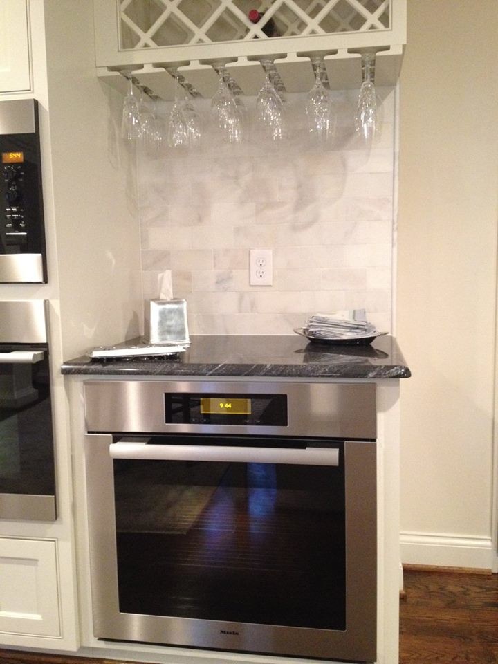 Inspiration for a large transitional l-shaped medium tone wood floor and brown floor kitchen remodel with beaded inset cabinets, white cabinets, white backsplash, subway tile backsplash, a farmhouse sink, stainless steel appliances and an island