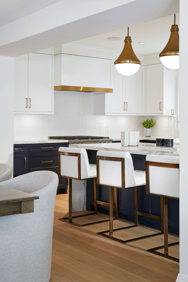 Large transitional l-shaped light wood floor eat-in kitchen photo in Toronto with recessed-panel cabinets, blue cabinets, white backsplash, stainless steel appliances, an island and white countertops