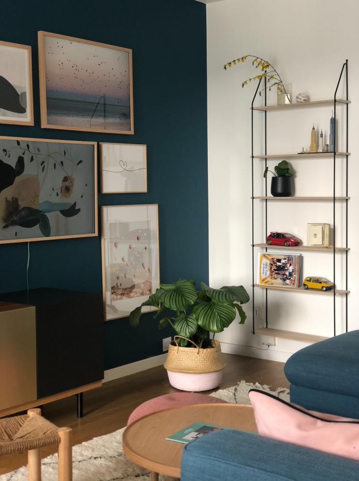 Small scandi open plan living room in Lyon with blue walls, light hardwood flooring, no fireplace, a wall mounted tv and brown floors.