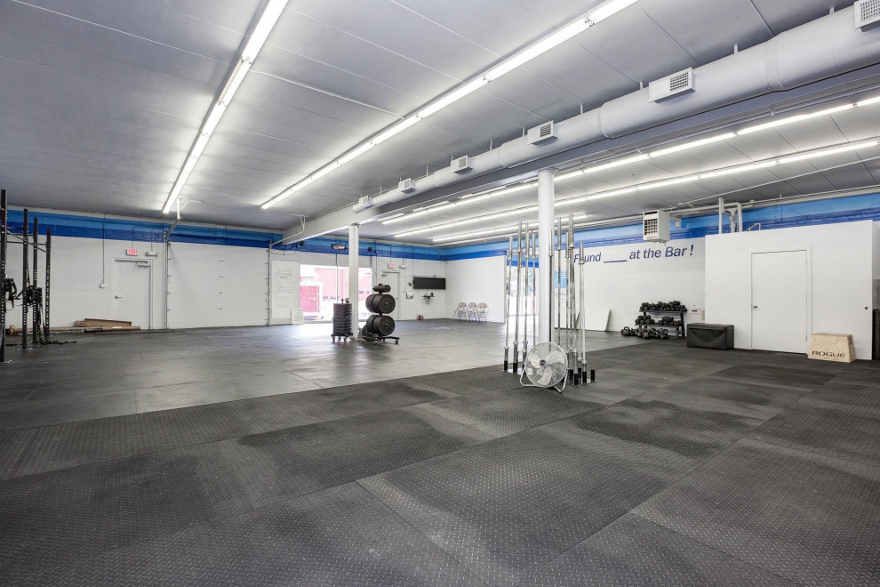 Multifunktionaler, Geräumiger Industrial Fitnessraum mit weißer Wandfarbe, Korkboden und schwarzem Boden in Washington, D.C.