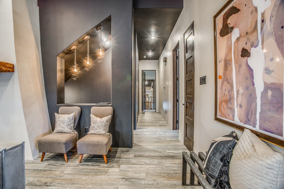 This is an example of a contemporary hallway in Austin with beige walls, light hardwood floors and grey floor.