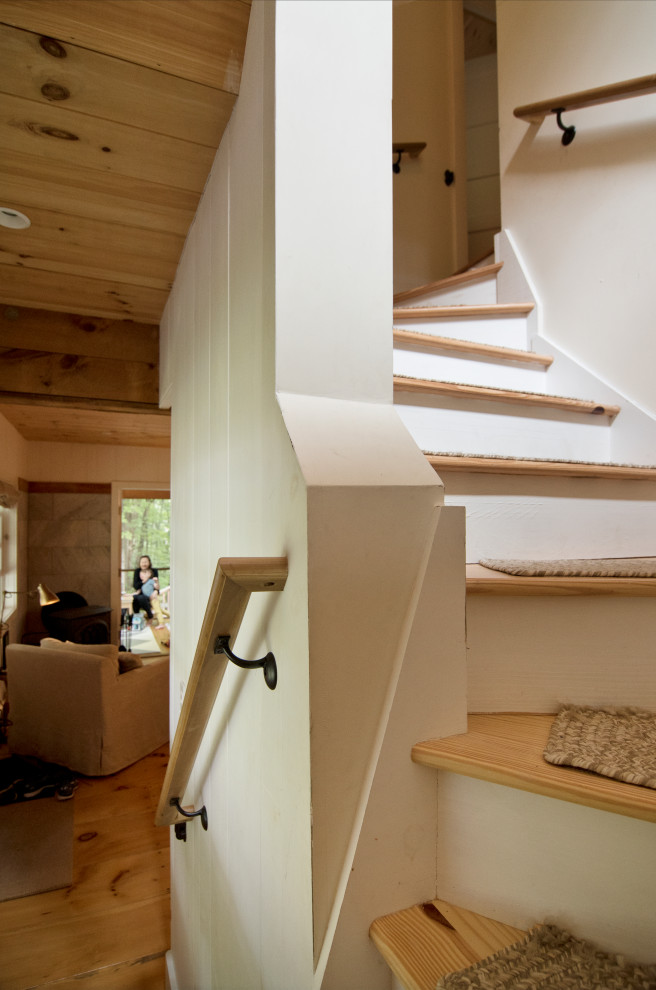 Small traditional wood staircase in New York with wood risers and wood railing.