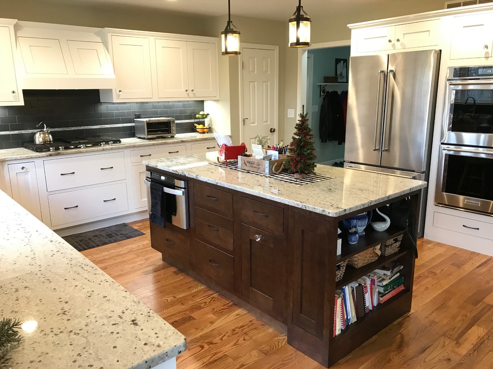 This is an example of a large traditional u-shaped eat-in kitchen in Other with an undermount sink, beaded inset cabinets, white cabinets, granite benchtops, grey splashback, glass tile splashback, stainless steel appliances, medium hardwood floors, no island and brown floor.