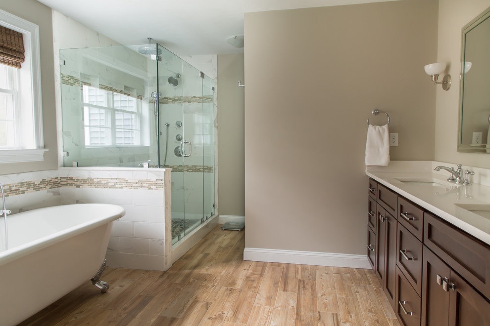 Mid-sized transitional master bathroom in Boston with a freestanding tub, a corner shower, beige walls, light hardwood floors, an undermount sink, shaker cabinets, dark wood cabinets, porcelain tile and engineered quartz benchtops.