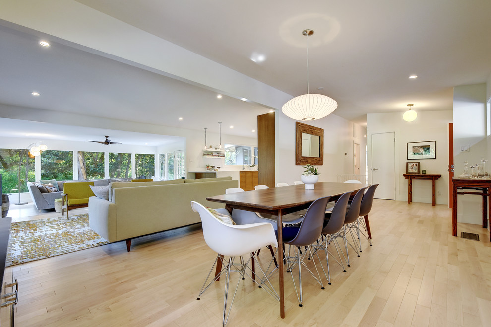 Photo of a large midcentury open plan dining in Austin with white walls, light hardwood floors and no fireplace.