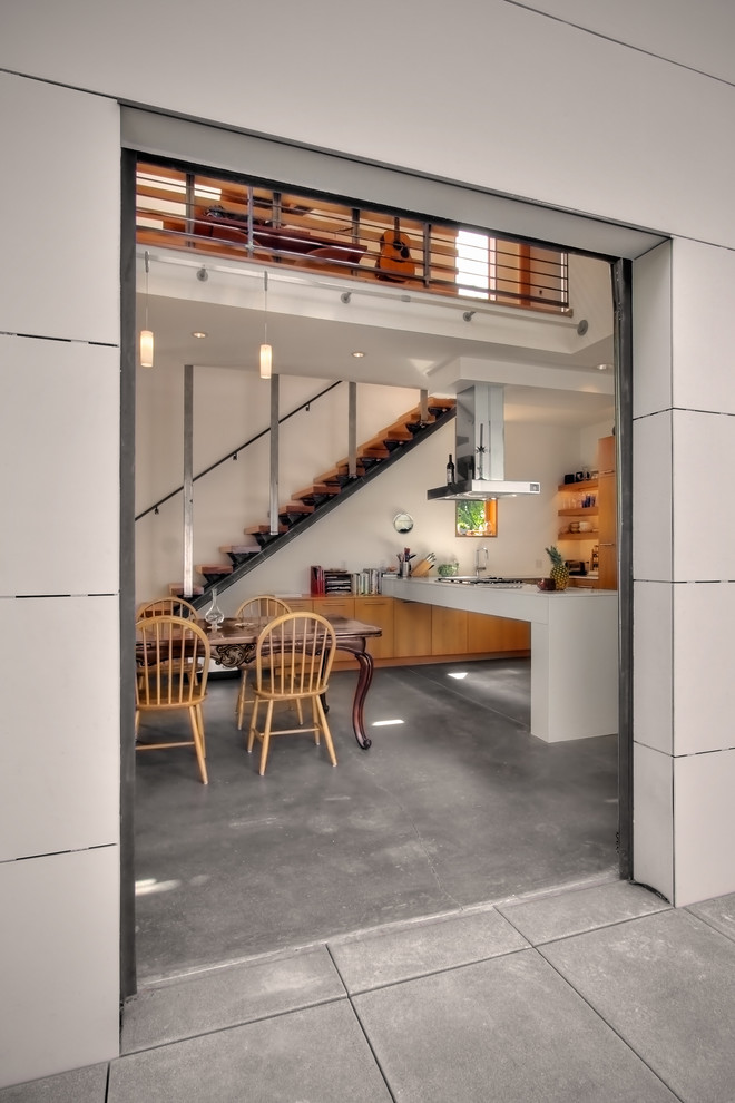 This is an example of an industrial dining room in Seattle with concrete floors.