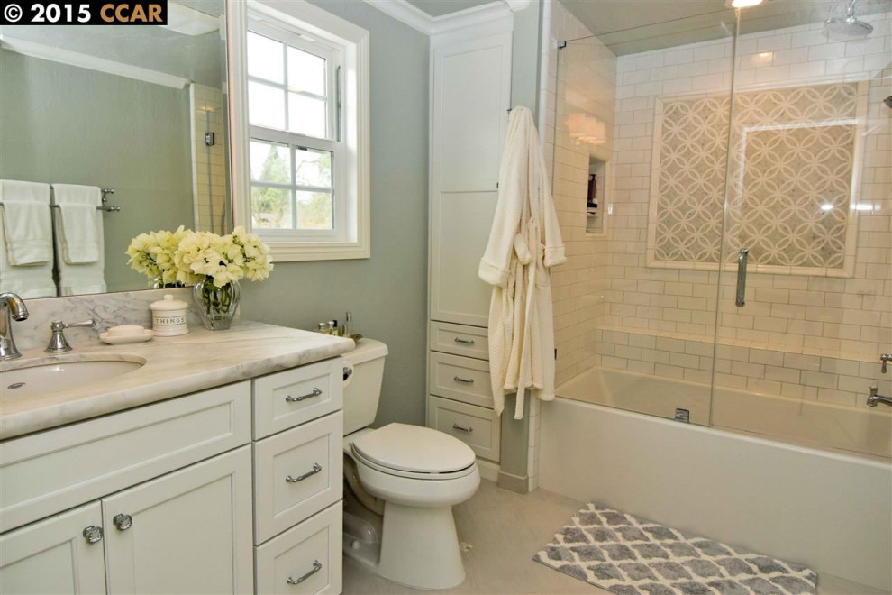 Mid-sized country master bathroom in San Francisco with shaker cabinets, white cabinets, an alcove tub, a shower/bathtub combo, a two-piece toilet, white tile, subway tile, green walls, porcelain floors, an undermount sink, marble benchtops, beige floor, a hinged shower door, white benchtops, a niche, a single vanity and a built-in vanity.