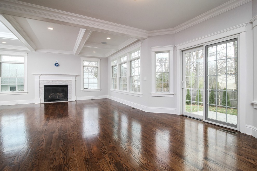 This is an example of a mid-sized traditional formal open concept living room in New York with grey walls, dark hardwood floors, a standard fireplace, a stone fireplace surround, no tv and brown floor.