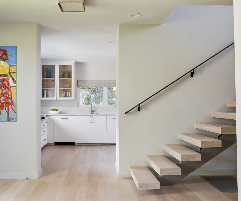 This is an example of a mid-sized contemporary wood floating staircase in Austin with metal railing.