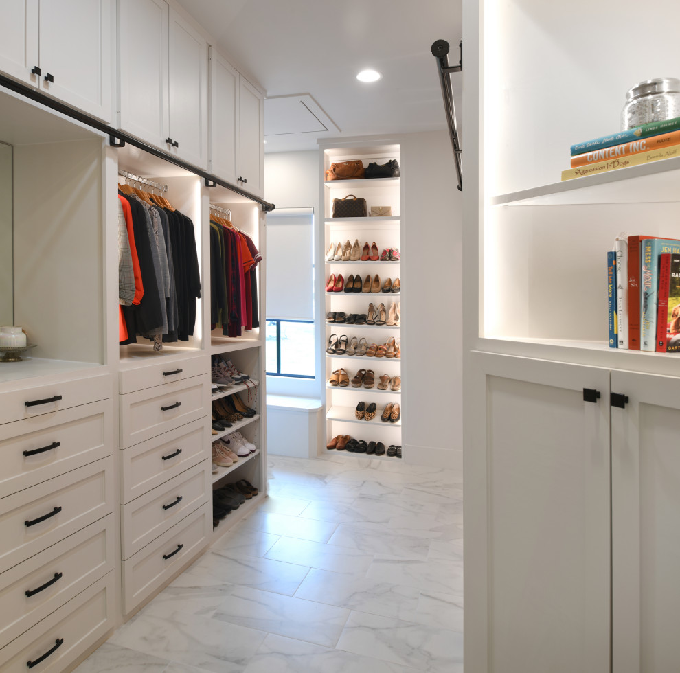 This is an example of a large transitional gender-neutral dressing room in Houston with white cabinets and porcelain floors.