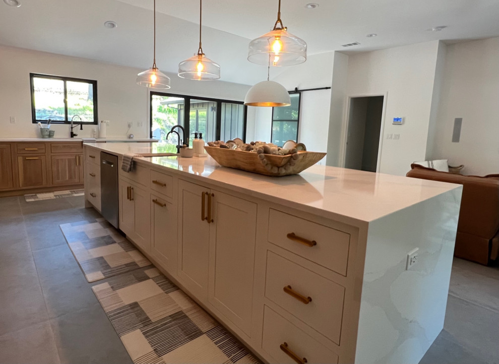 Photo of a large transitional u-shaped eat-in kitchen in Las Vegas with an undermount sink, shaker cabinets, white cabinets, quartzite benchtops, white splashback, ceramic splashback, stainless steel appliances, slate floors, with island, grey floor, white benchtop and vaulted.