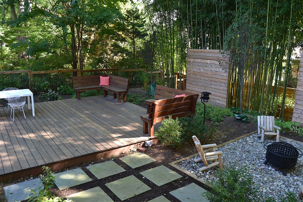 This is an example of a mid-sized midcentury backyard deck in DC Metro with no cover and a fire feature.