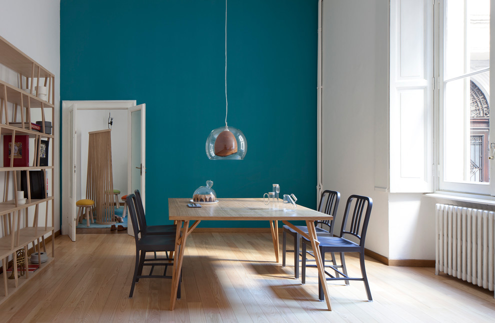 Large scandinavian dining room in Milan with light hardwood floors and blue walls.