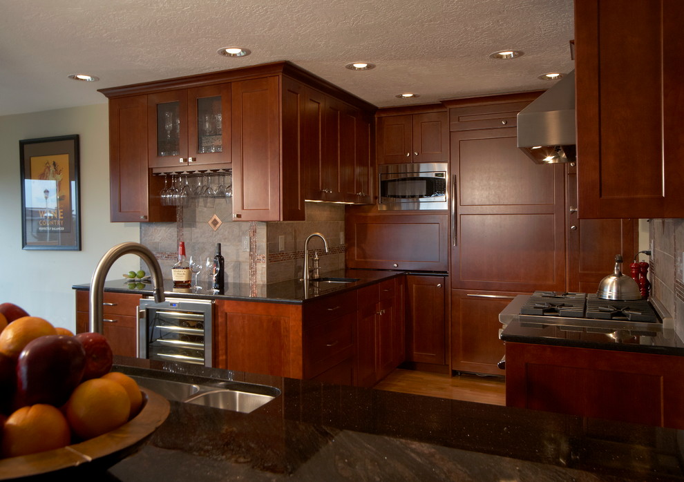 Mid-sized transitional l-shaped light wood floor and beige floor open concept kitchen photo in Seattle with an undermount sink, raised-panel cabinets, medium tone wood cabinets, granite countertops, metallic backsplash, ceramic backsplash, stainless steel appliances and no island