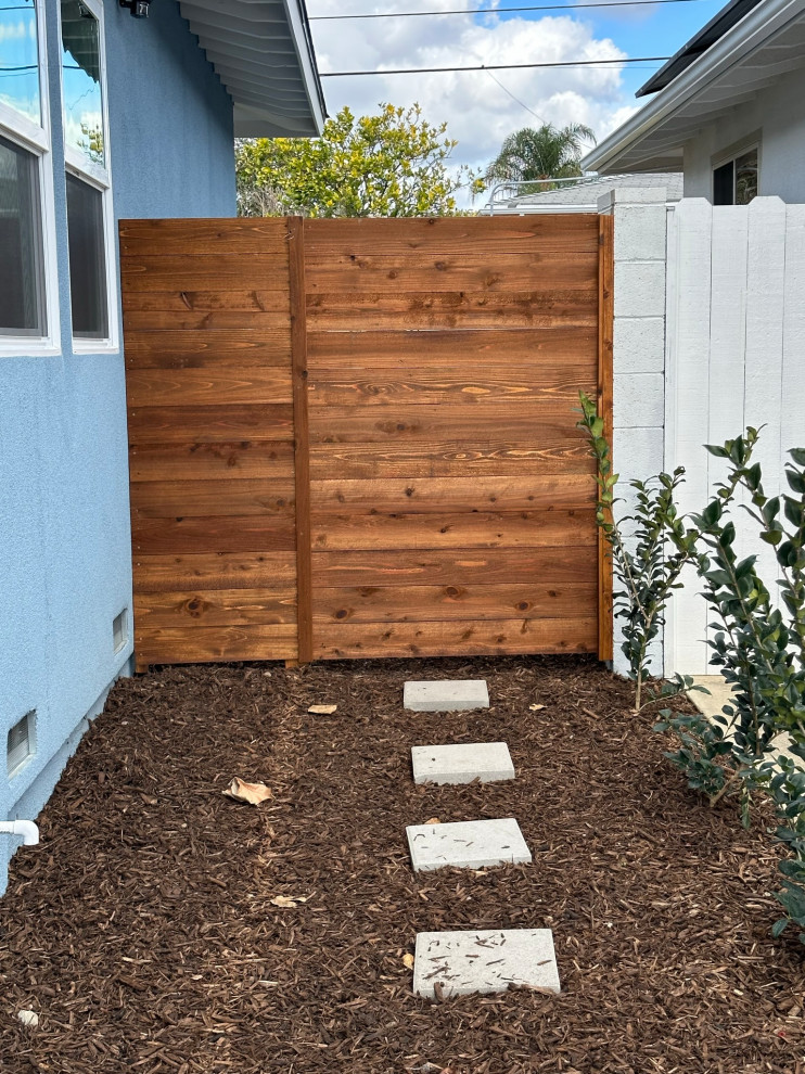 Modernes Gartentor neben dem Haus mit Mulch und Holzzaun in Orange County
