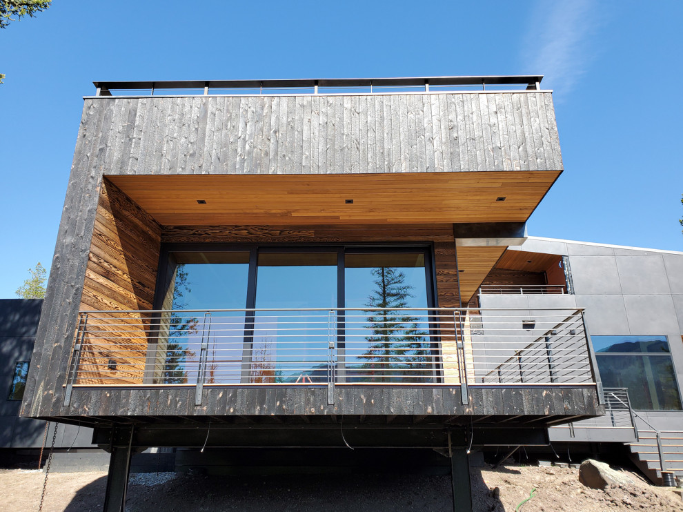 Zweistöckiges Modernes Einfamilienhaus mit Mix-Fassade, schwarzer Fassadenfarbe und Blechdach in Sonstige