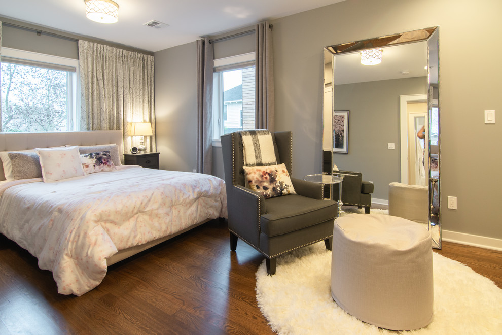 Design ideas for a mid-sized eclectic master bedroom in Seattle with grey walls, medium hardwood floors, white floor, a standard fireplace and a wood fireplace surround.