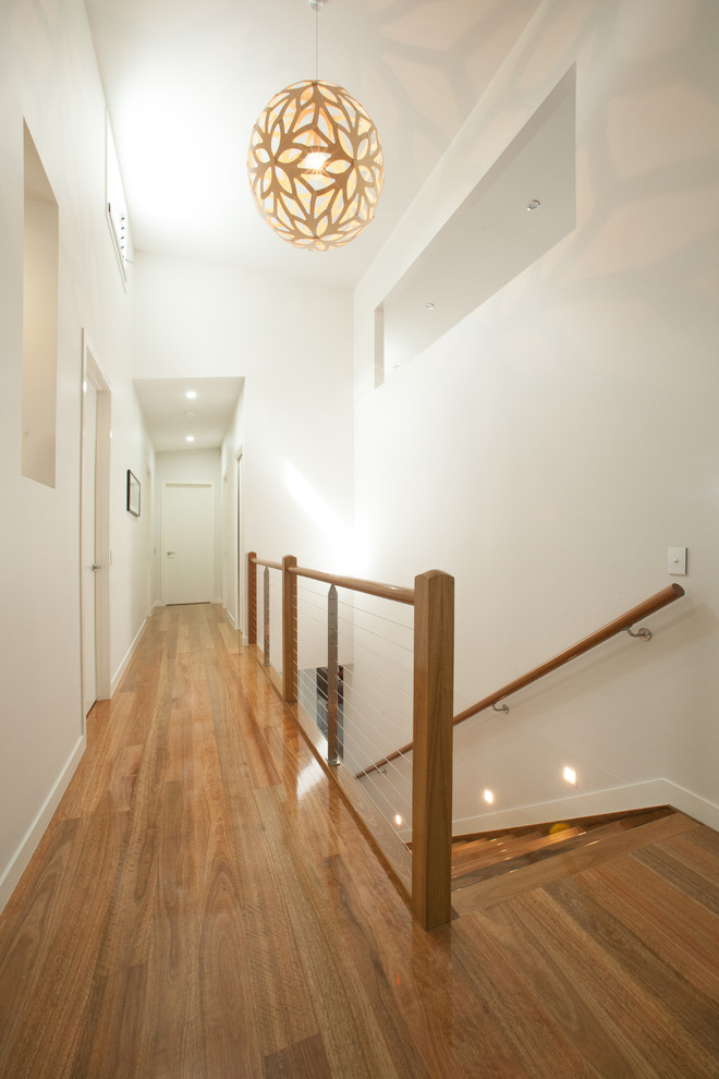 Inspiration for a large contemporary hallway in Brisbane with white walls and medium hardwood floors.