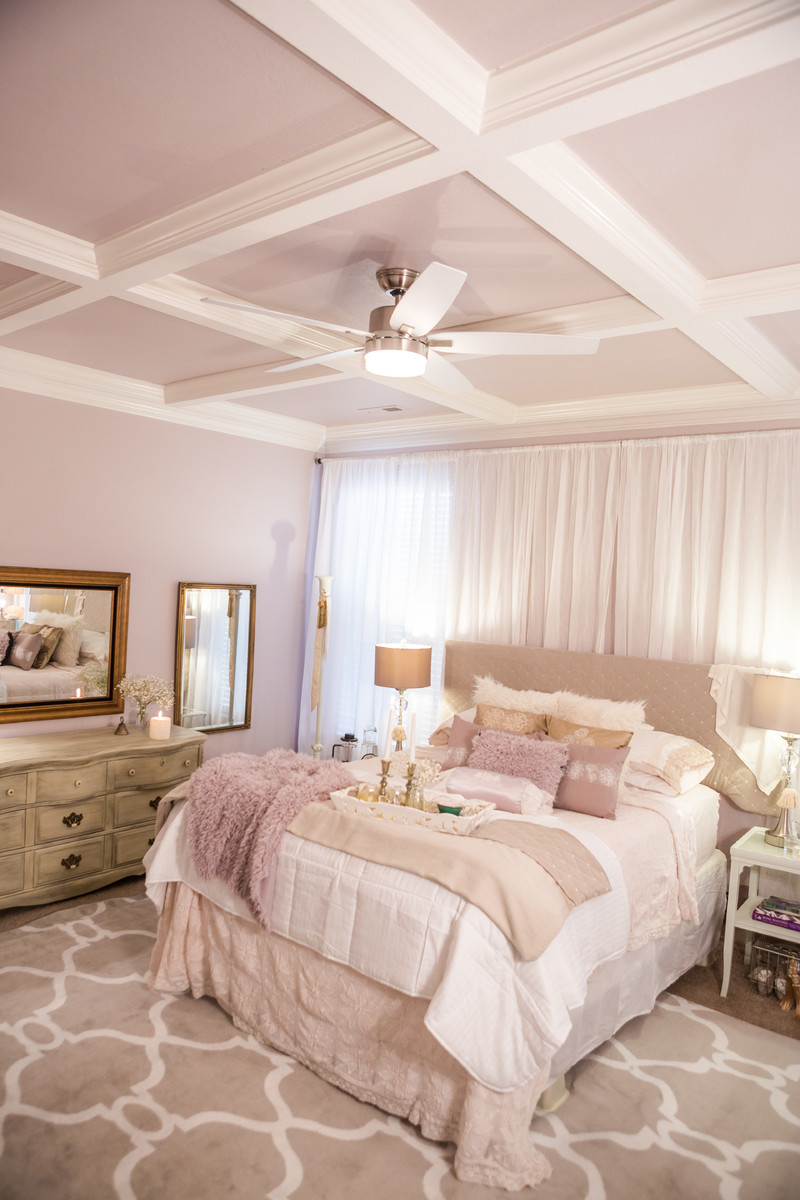 This is an example of a large traditional master bedroom in Other with pink walls, carpet, a hanging fireplace, a metal fireplace surround and white floor.