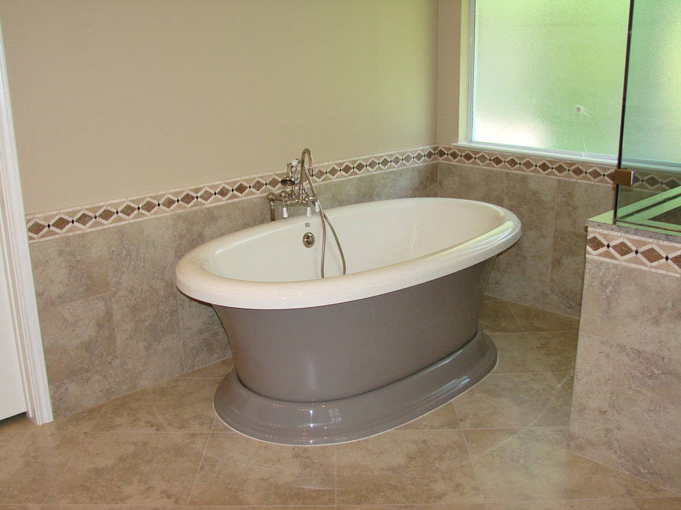 Photo of a mid-sized transitional master bathroom in Houston with an undermount sink, raised-panel cabinets, medium wood cabinets, granite benchtops, a freestanding tub, an open shower, a one-piece toilet, beige tile, stone tile, beige walls and ceramic floors.