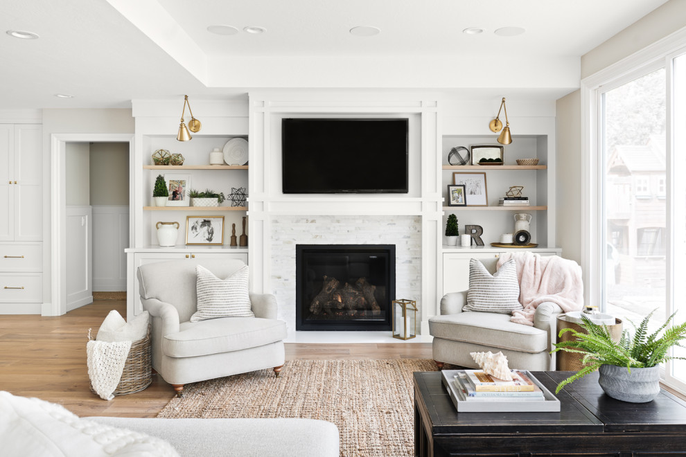 Inspiration for a mid-sized transitional open concept living room in San Francisco with grey walls, medium hardwood floors, a standard fireplace, a stone fireplace surround, brown floor and a wall-mounted tv.
