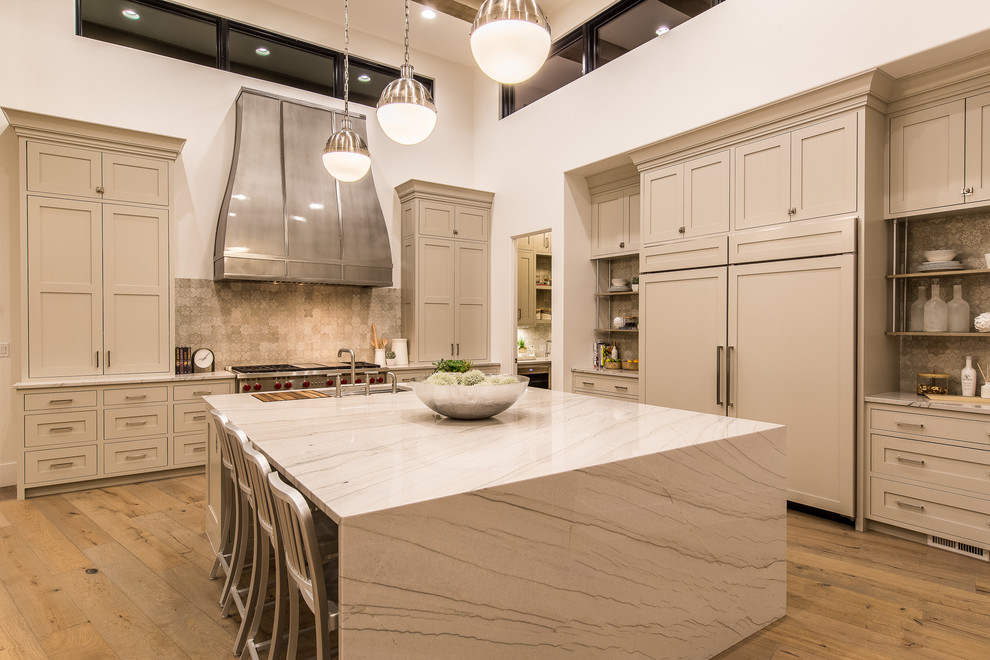 Eat-in kitchen - huge transitional l-shaped light wood floor and beige floor eat-in kitchen idea in Las Vegas with shaker cabinets, beige cabinets, marble countertops, beige backsplash, stainless steel appliances and an island
