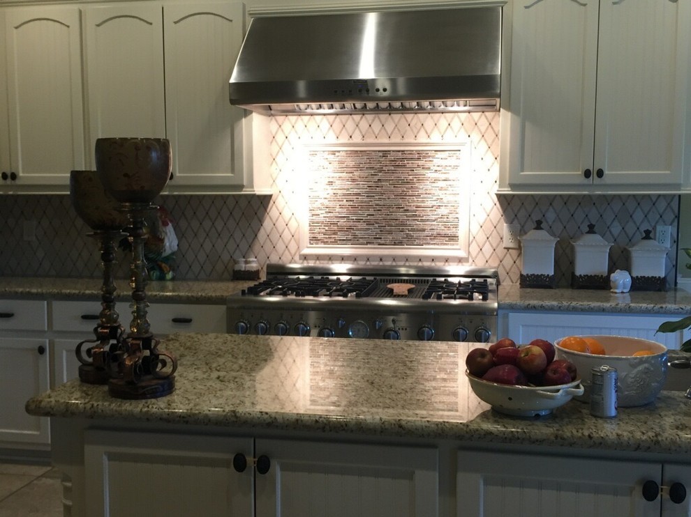 Example of a transitional kitchen design in Austin with recessed-panel cabinets, white cabinets, granite countertops, multicolored backsplash, porcelain backsplash, stainless steel appliances, an island and multicolored countertops